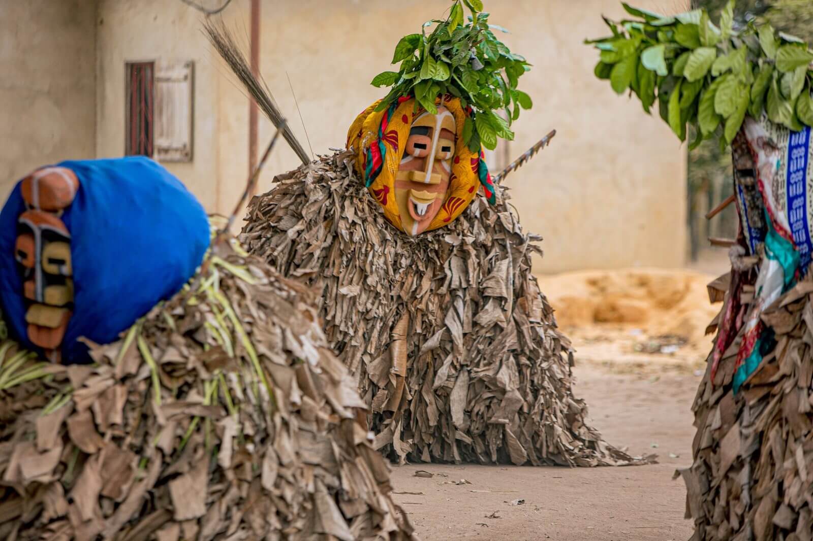Performers tradicionais com trajes de folha e máscaras
